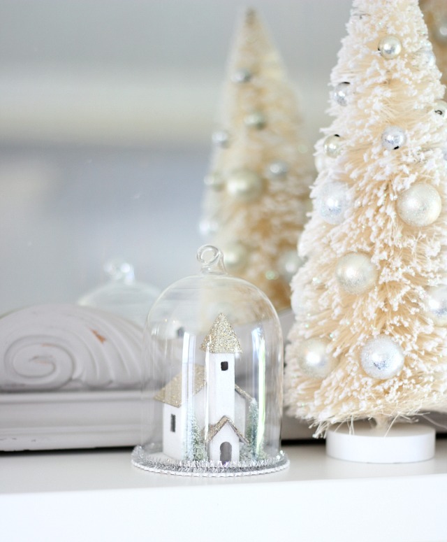 Church Cloche Ornament with Bottle Brush Trees on White Fireplace Mantel