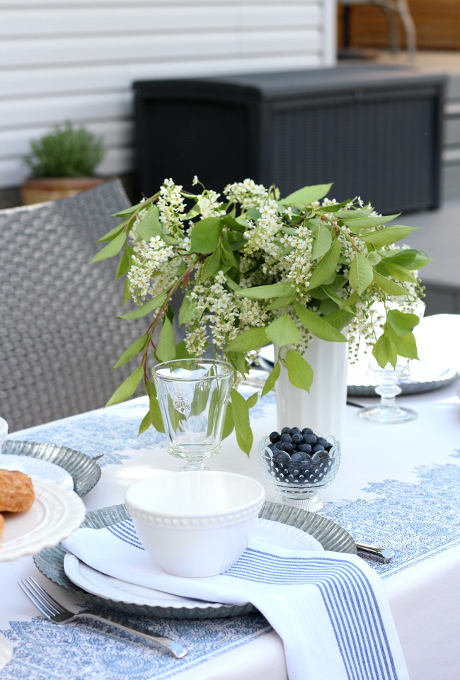 Milk Glass Vase Filled with Spring Blossoms on Outdoor Table