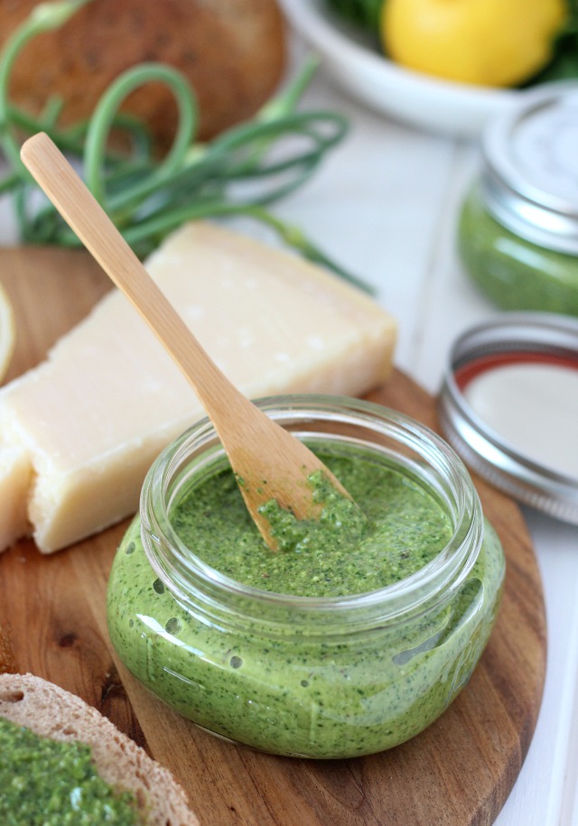 Homemade Spinach Basil Pesto with Garlic Scapes in Jar with Bamboo Spreader Knife