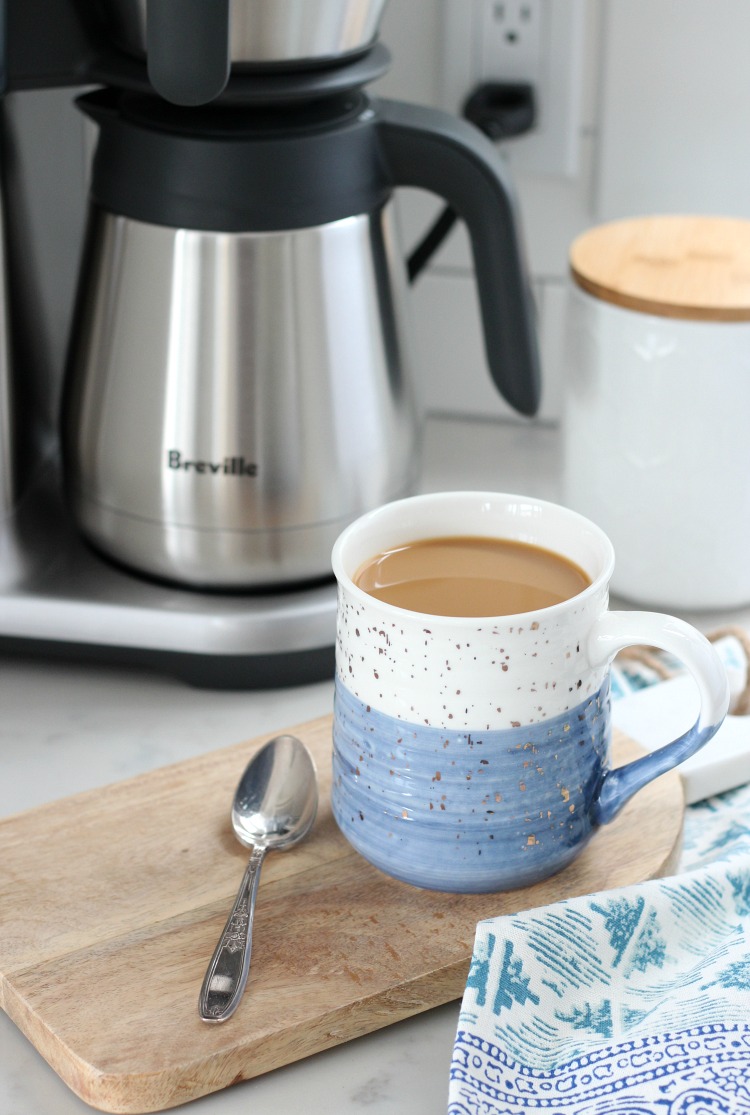 Blue and White Mug Filled with Coffee on Wooden Board with Breville Coffee Maker in Background