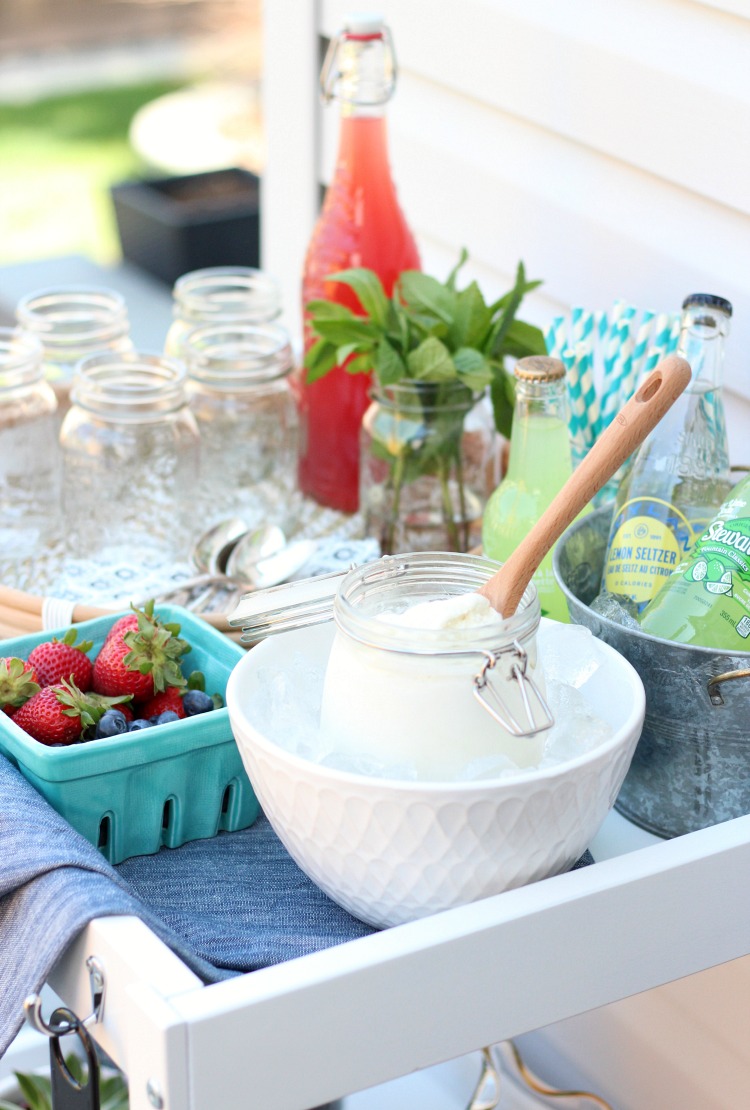 Ice Cream Float Bar Set Up on White Bar Cart with Ice Cream, Bottles of Soda and Toppings