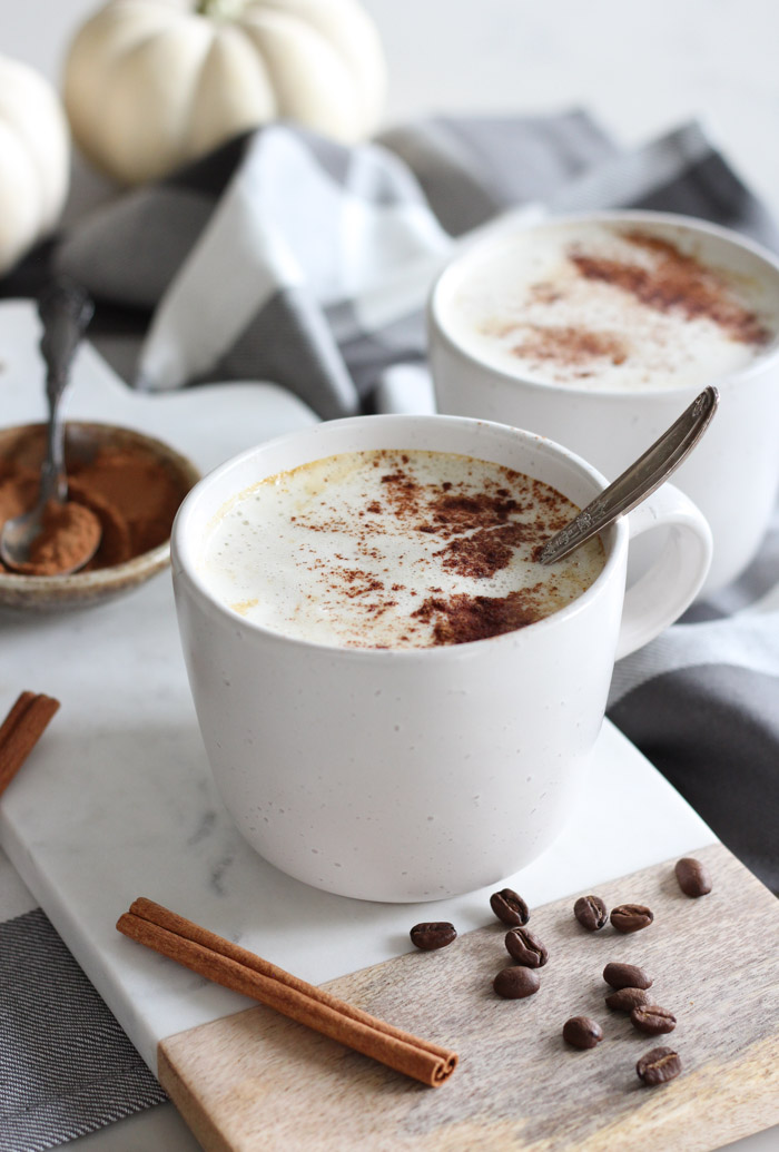 Pumpkin Spice Latte in White Mug with Cinnamon on Wood and Marble Serving Board