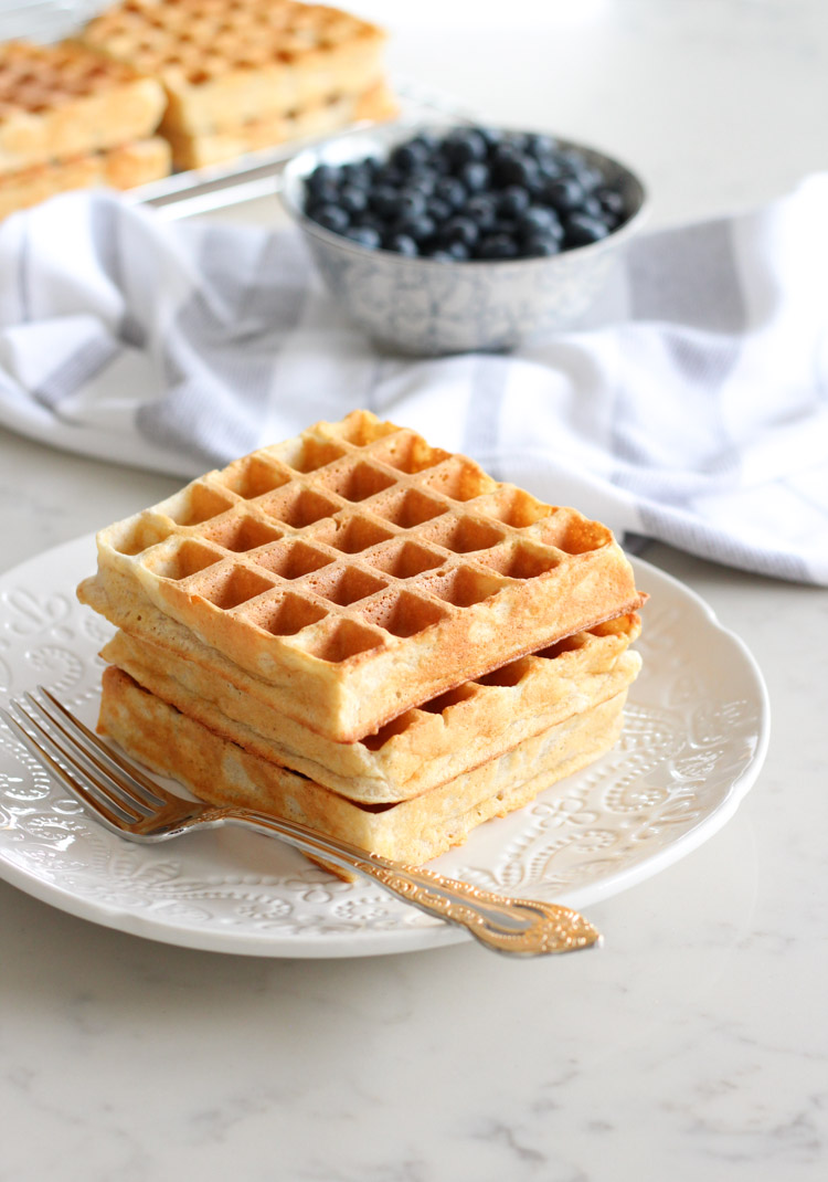 Stack of Three Waffles on White Plate with Bowl of Fresh Blueberries