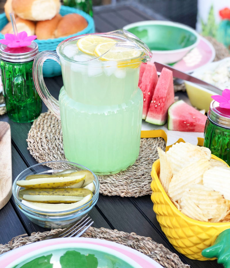 Outdoor Table Setting with Picnic Food, Including Pitcher of Limeade, Bowl of Potato Chips and Plate of Watermelon