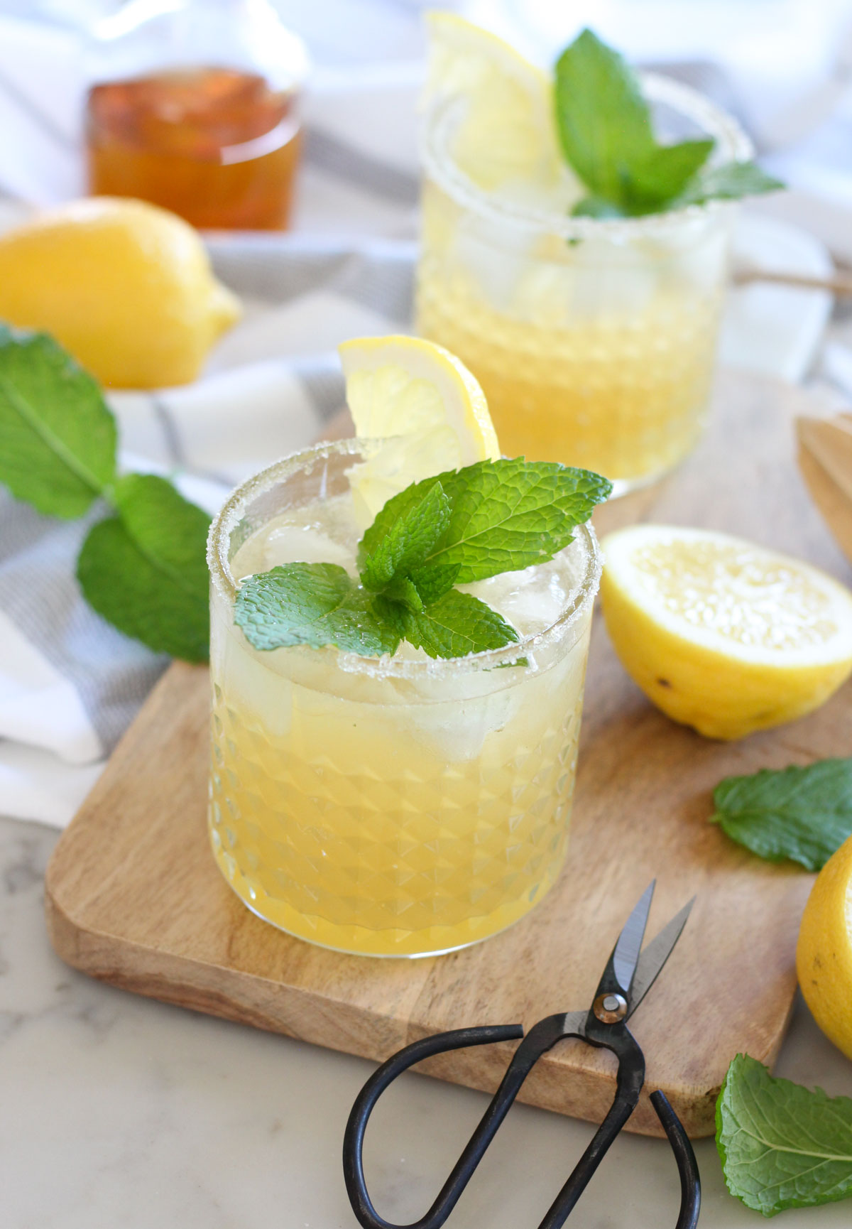 Bourbon Lemonade Cocktail in Short Glass Garnished with Fresh Mint and Lemon Wedge
