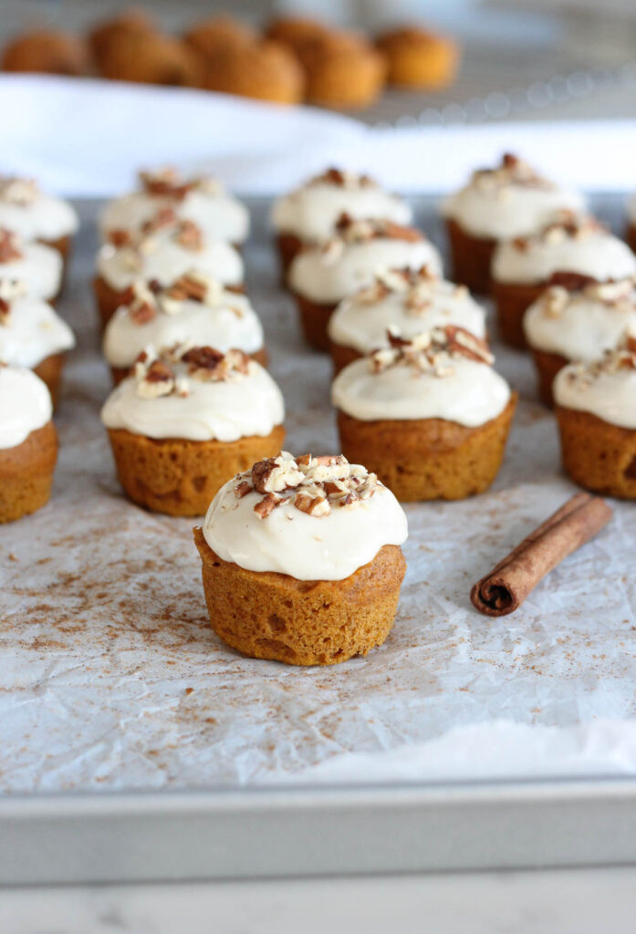Batch of Mini Pumpkin Spice Cupcakes with Maple Cream Cheese Frosting Topped with Pecans