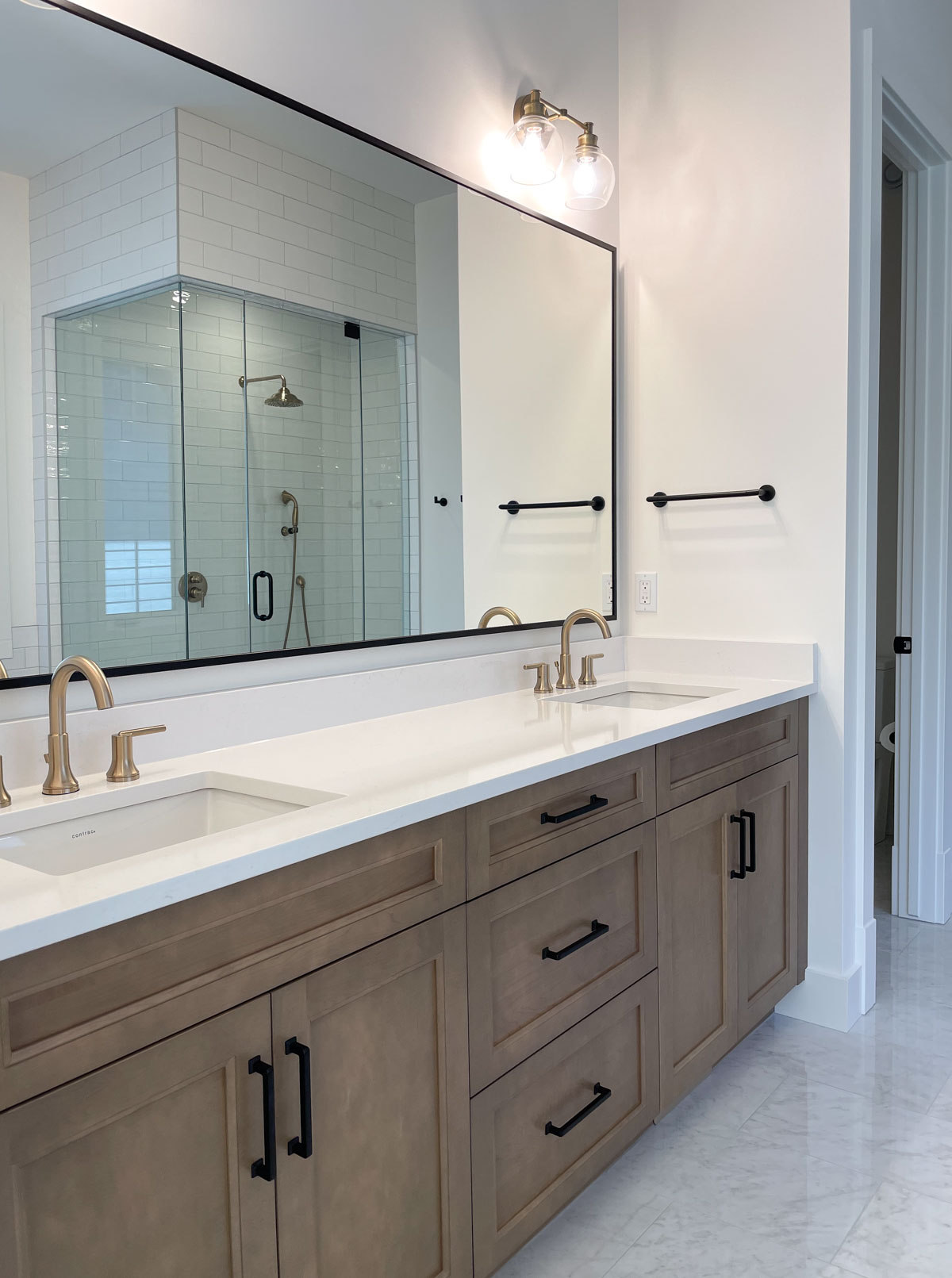 Wood vanity with drawers and double sinks in primary bathroom