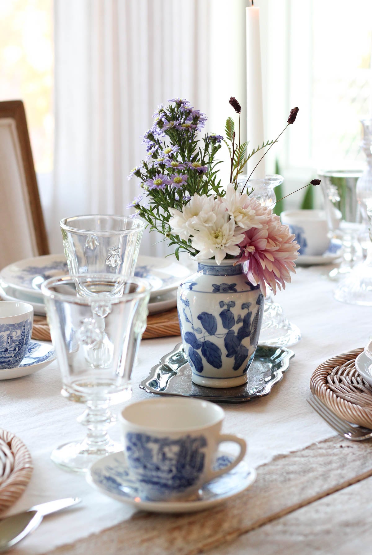 Dining table set with vintage blue and white dishes and flowers in chinoiserie vase