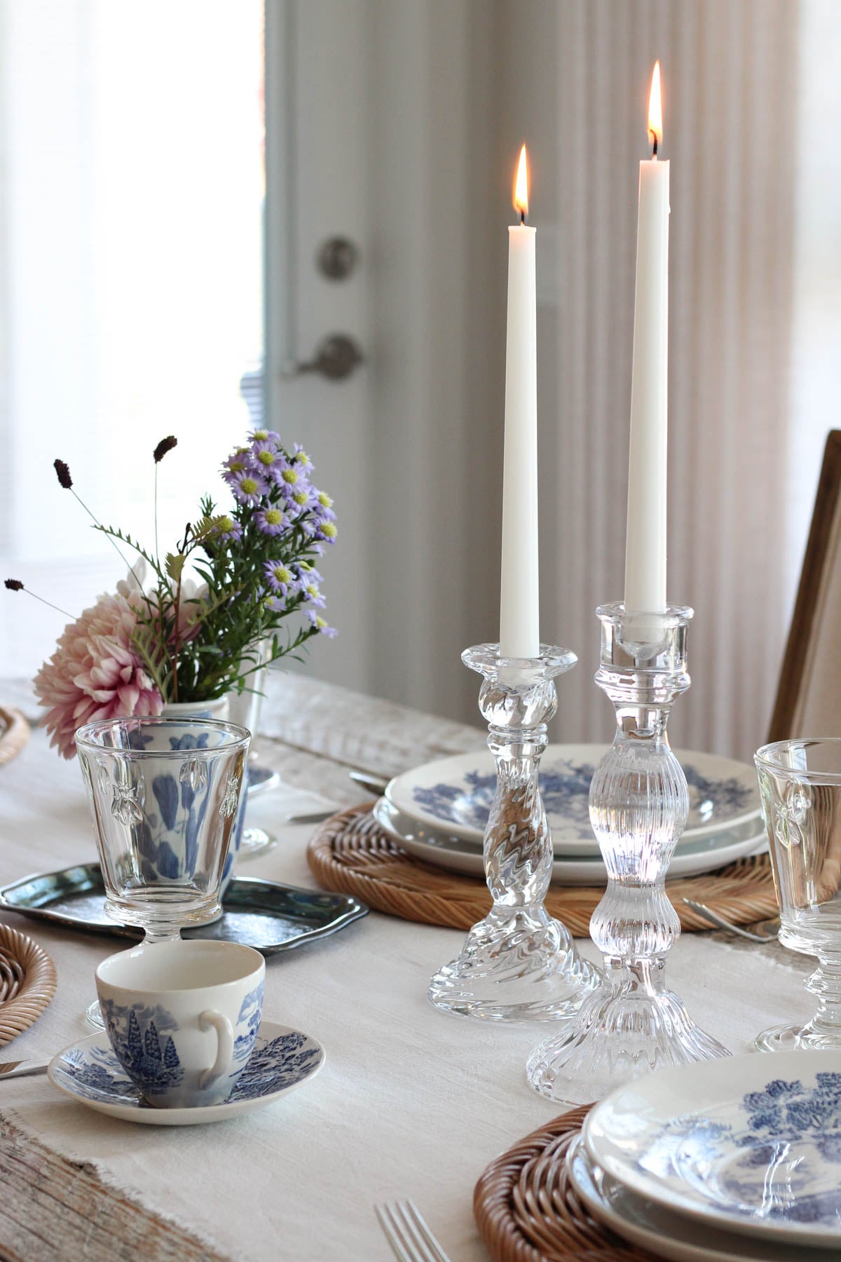 Table setting with white tapered candles in glass candle holders
